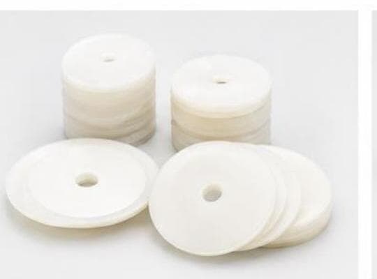 UHMWPE plastic test discs for mechanical wear testing.