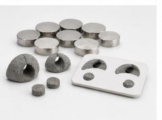 Porous titanium pucks and biocompatible polymer test specimens.